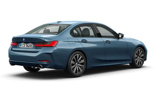 Das Bild zeigt die Heckansicht einer BMW Limousine (wahrscheinlich ein 3er Modell) in einem matten Blauton auf weißem Hintergrund. Die Aufnahme hebt das Design des Hecks hervor, einschließlich der L-förmigen LED-Rückleuchten. Man sieht die Auspuffendrohre auf der linken Seite. Wie in der vorherigen Ansicht ist das Fahrzeug mit zweifarbigen Felgen ausgestattet. Die Seitenlinie ist klar und elegant. Das Kennzeichen "M CV 5628E" ist ebenfalls sichtbar.