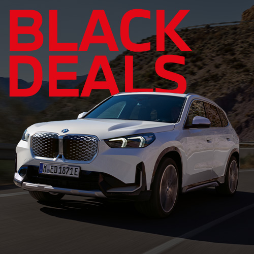 Dieses Bild zeigt einen weißen, elektrischen Kompakt-SUV (iX1). Das Fahrzeug wirkt modern und robust mit seiner markanten, geschlossenen Front. Die großen, roten Worte "BLACK DEALS" liegen über der Szene.